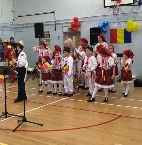 A group of people in traditional costume practising Romanian dance.