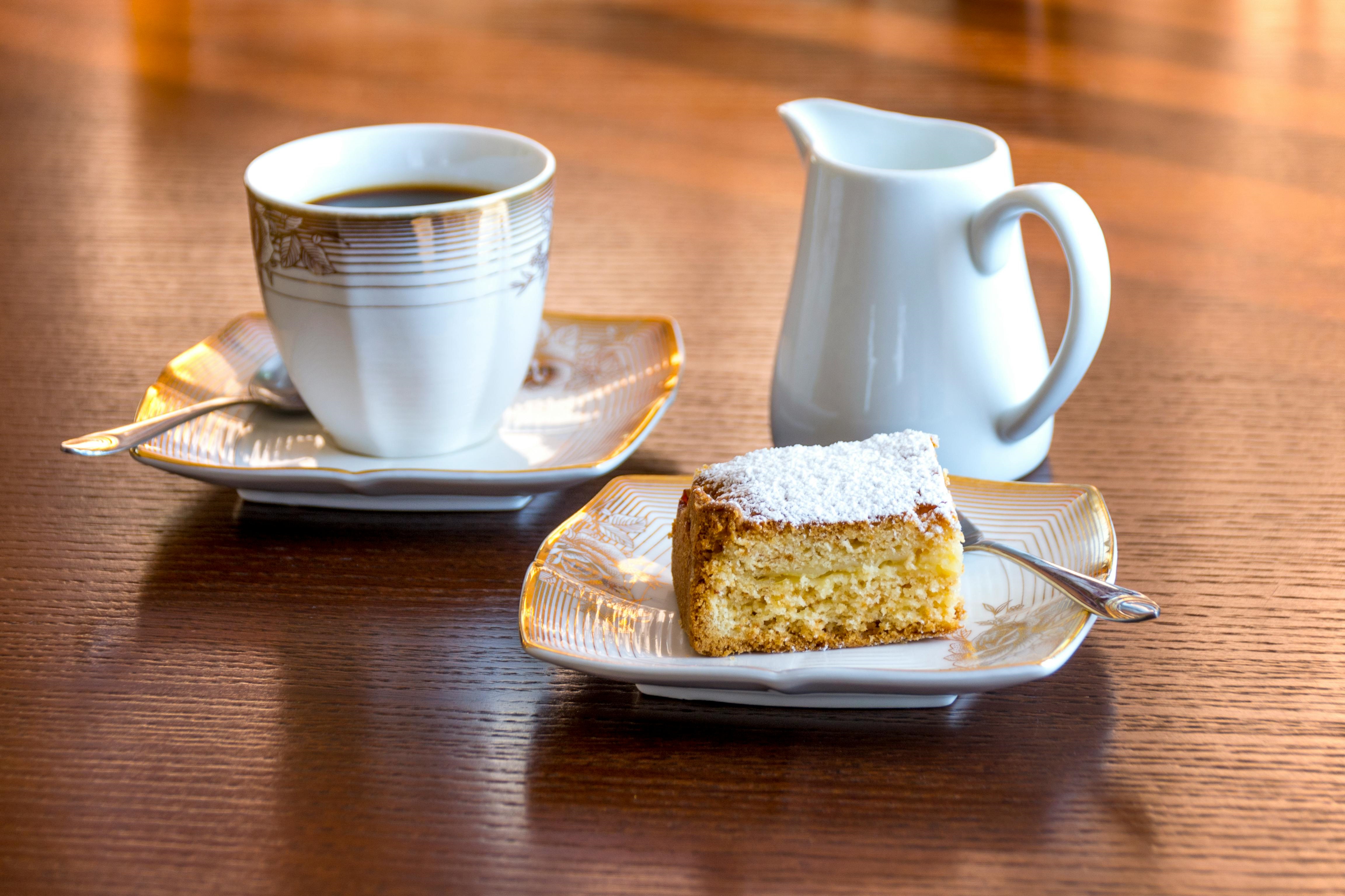 Tea cup, milk jug and cake